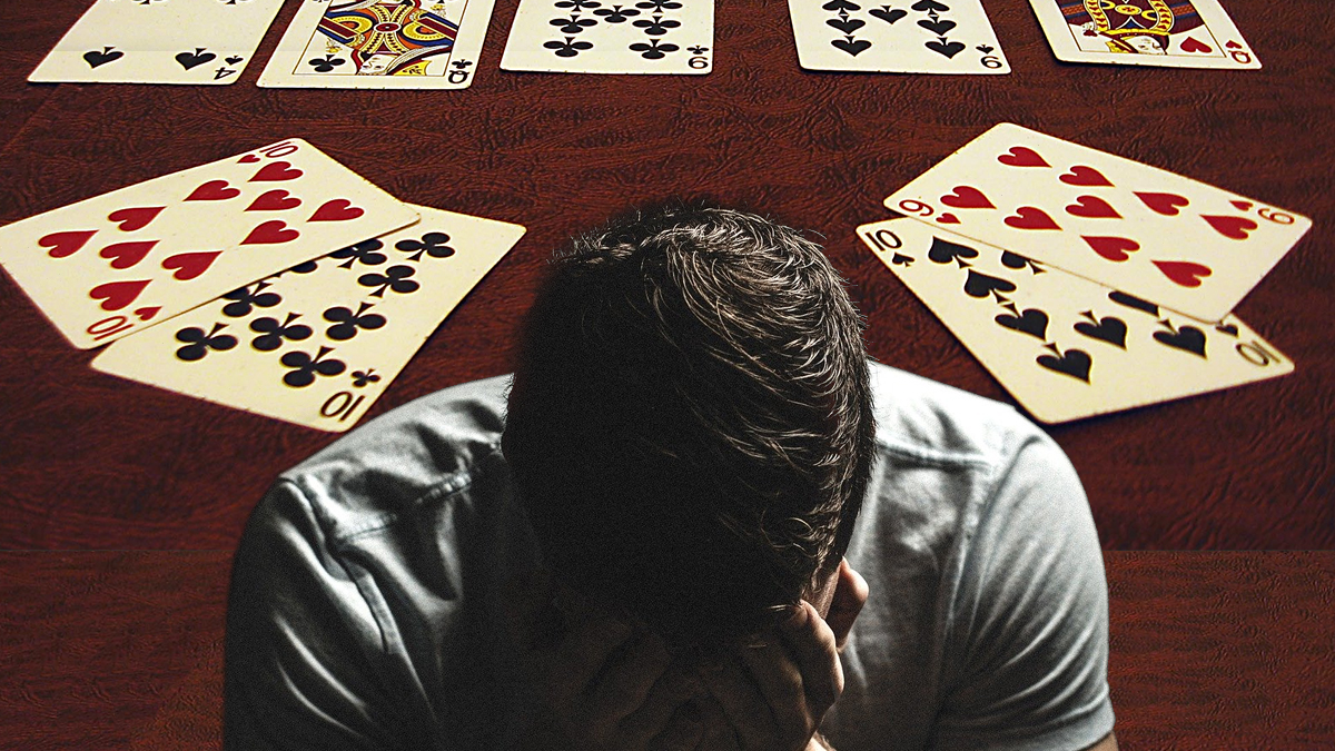 Pria Dengan Wajah di Tangan Dengan Latar Belakang Meja Poker