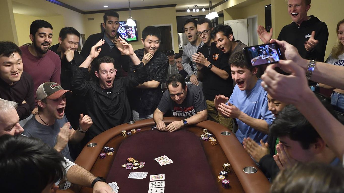 Avi Rubin loses his poker hand as students look on in amazement